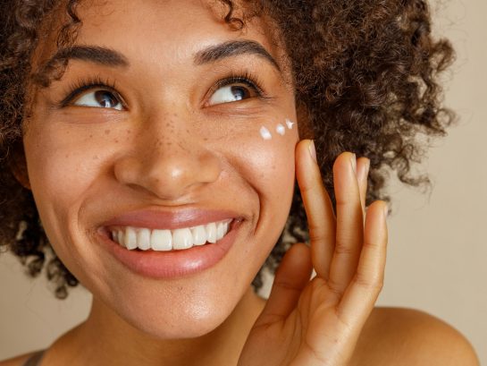 Young woman with cream on face in studio